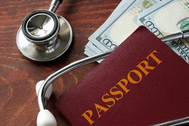 passport money and stethoscope on a table